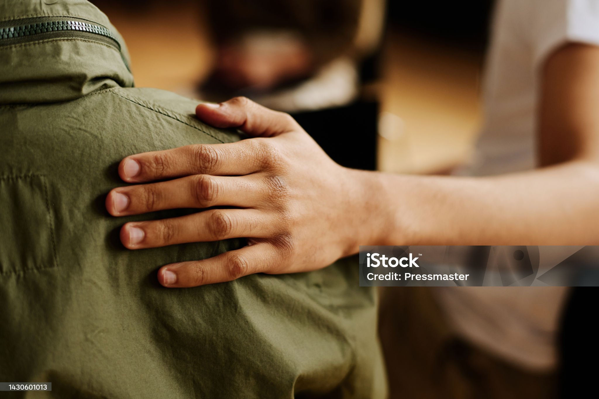 A hand resting reassuringly on someone&rsquo;s shoulder